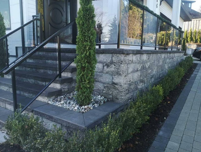 front porch retaining wall with tall shrubs