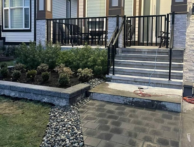 paver walkway up to staircase, next to garden retaining wall